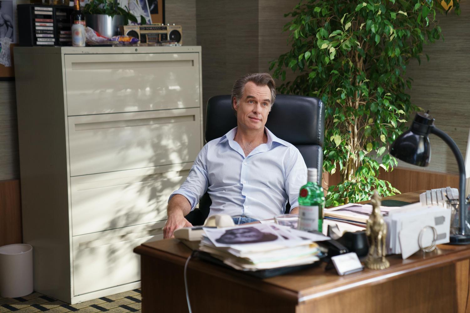 Murray Bartlett as Nick de Noia sits behind a desk in 'Welcome to Chippendales' Episode 7.