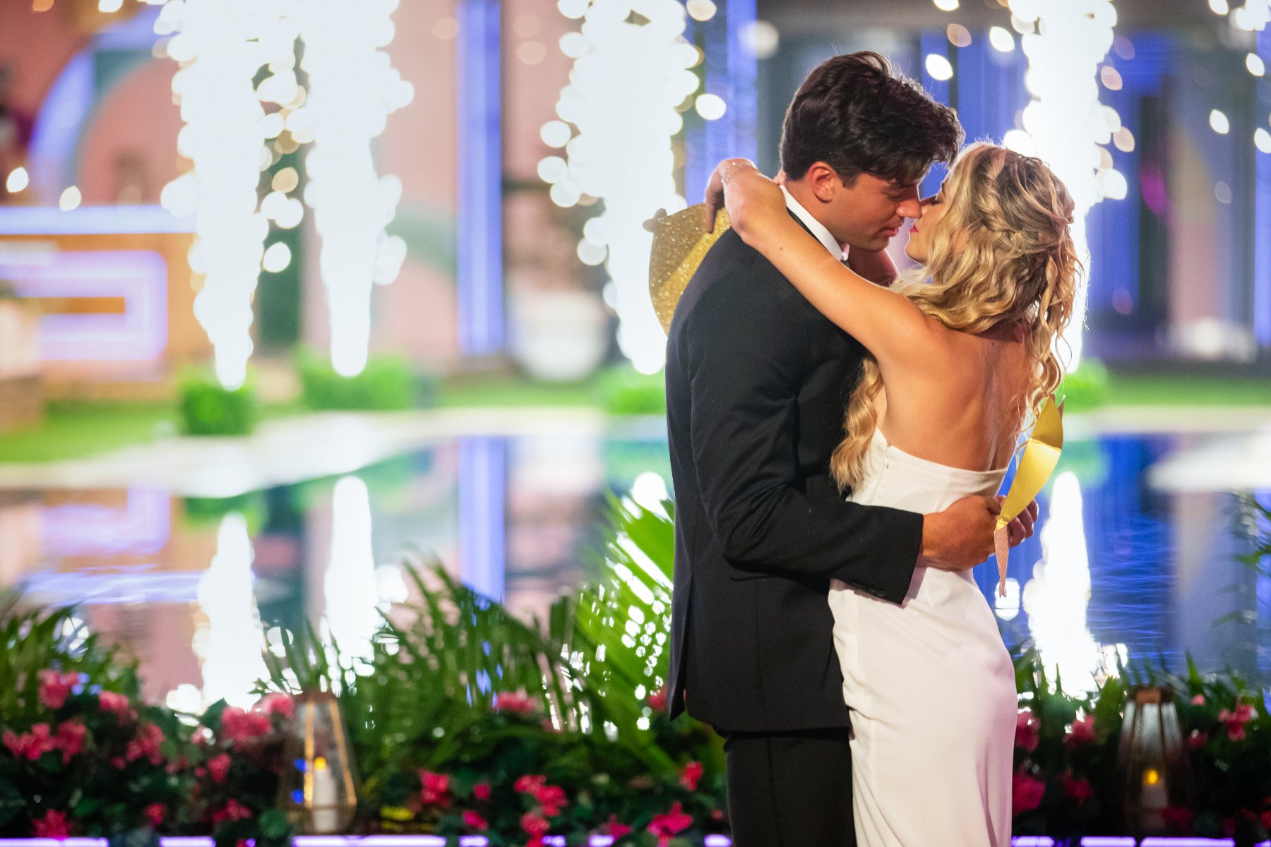 Zac Mirabelli and Elizabeth Weber for our article about who wins 'Love Island USA' Season 1. She's wearing a white wedding dress, and he's wearing a black suit. They're about to kiss.