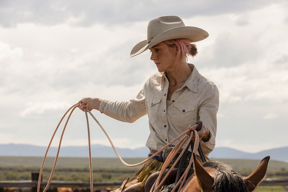 Colby and Teeter are a beloved couple in Yellowstone. Teeter sits on a horse, holding a rope and wearing a beige cowboy hat and shirt. 