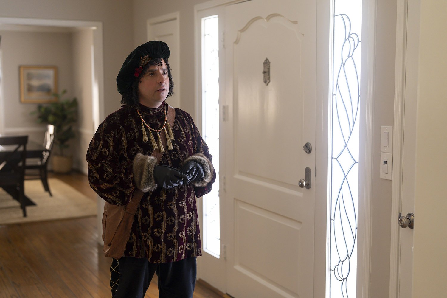 David Krumholtz as Bernard the Elf standing near a front door and looking concerned in The Santa Clauses