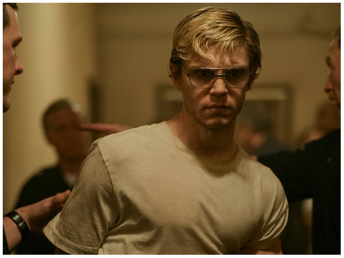Jeffrey Dahmer (Evan Peters) is escorted through the 'urinal cake yellow' halls of his apartment in 'DAHMER — Monster: The Jeffrey Dahmer Story,' which was inspired by a crime scene photo