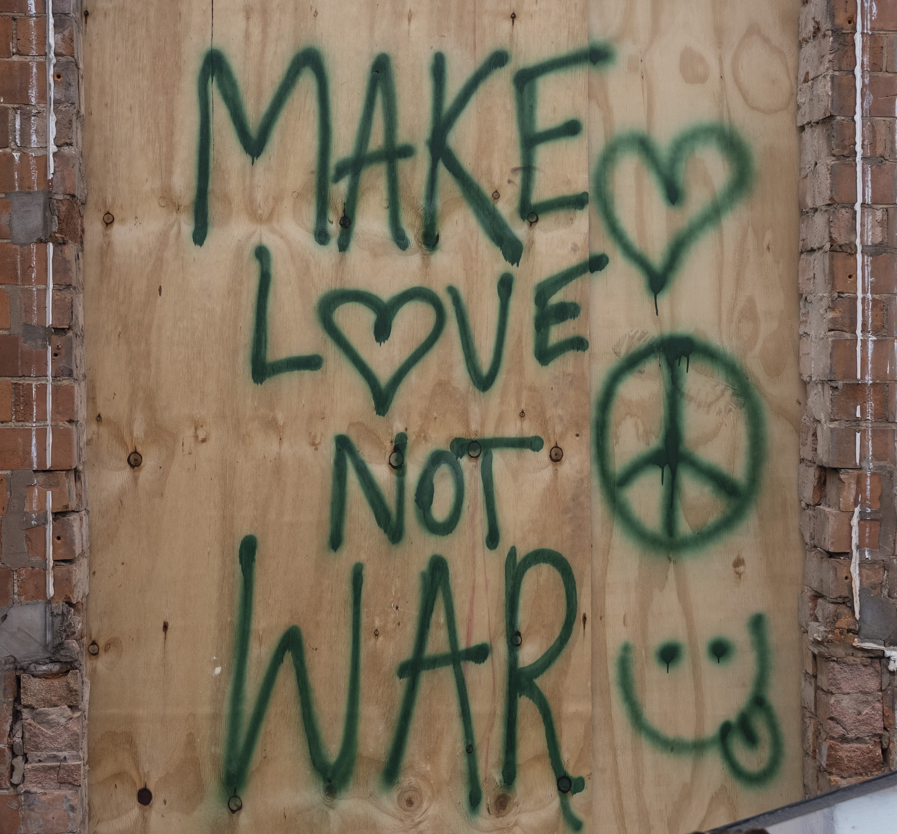 Graffiti reading "Make Love Not War" near a peace sign