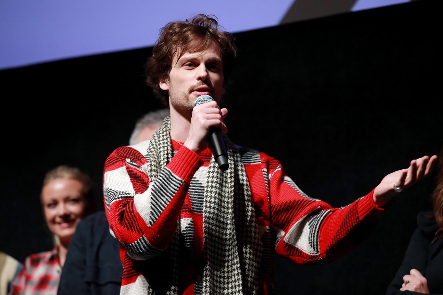 Matthew Gray Guler, who directed several episodes of Criminal Minds, speaks into a microphone while wearing a red, gray, and white patterned sweater at Sundance in 2020
