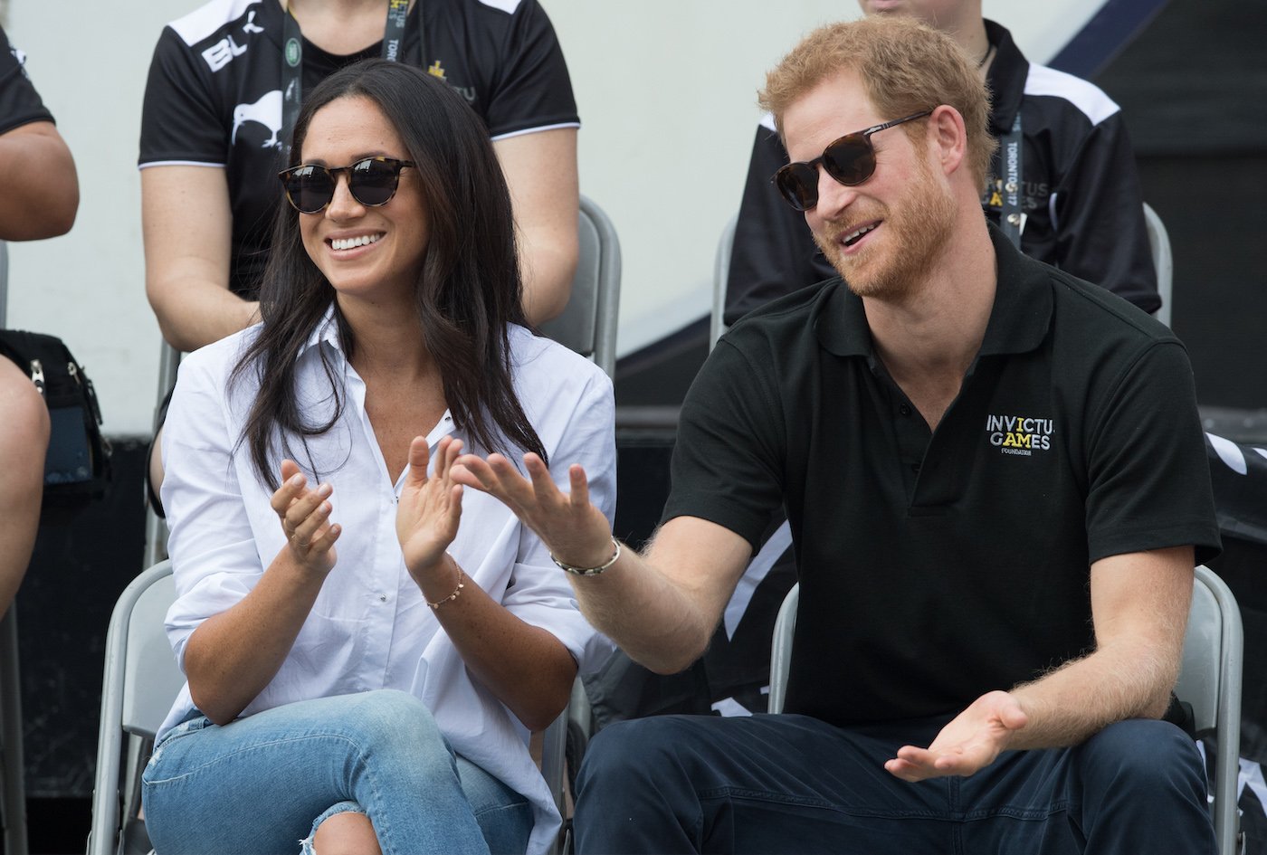 Meghan Markle and Prince Harry sit next to each other at a sporting event