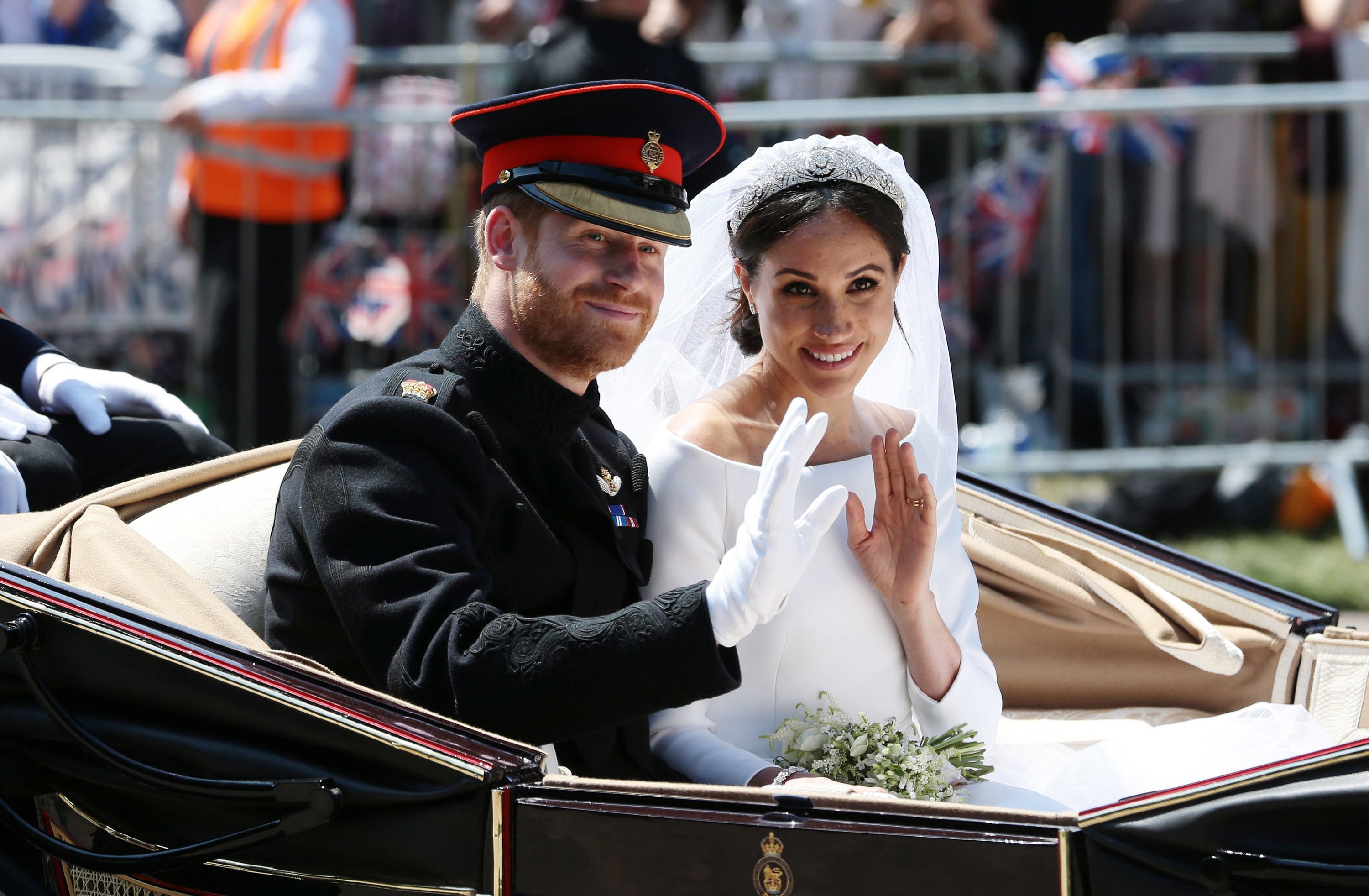 Prince Harry and Meghan Markle ride in a carriage on their wedding day.