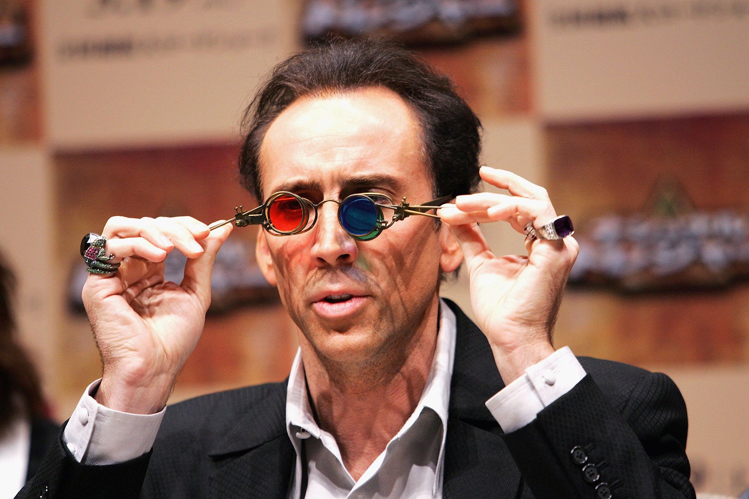 National Treasure 3 news: Nicolas Cage holds up Benjamin Franklin's colorful glasses from National Treasure at a 2004 press conference in Tokyo.