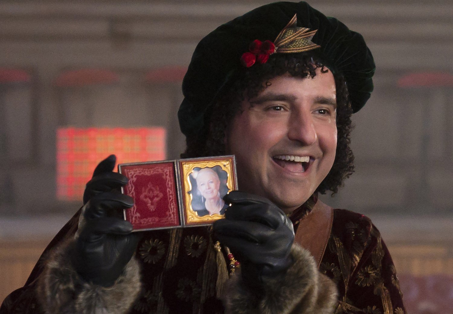 David Krumholtz as Bernard holding a framed photo of Vanessa Redgrave