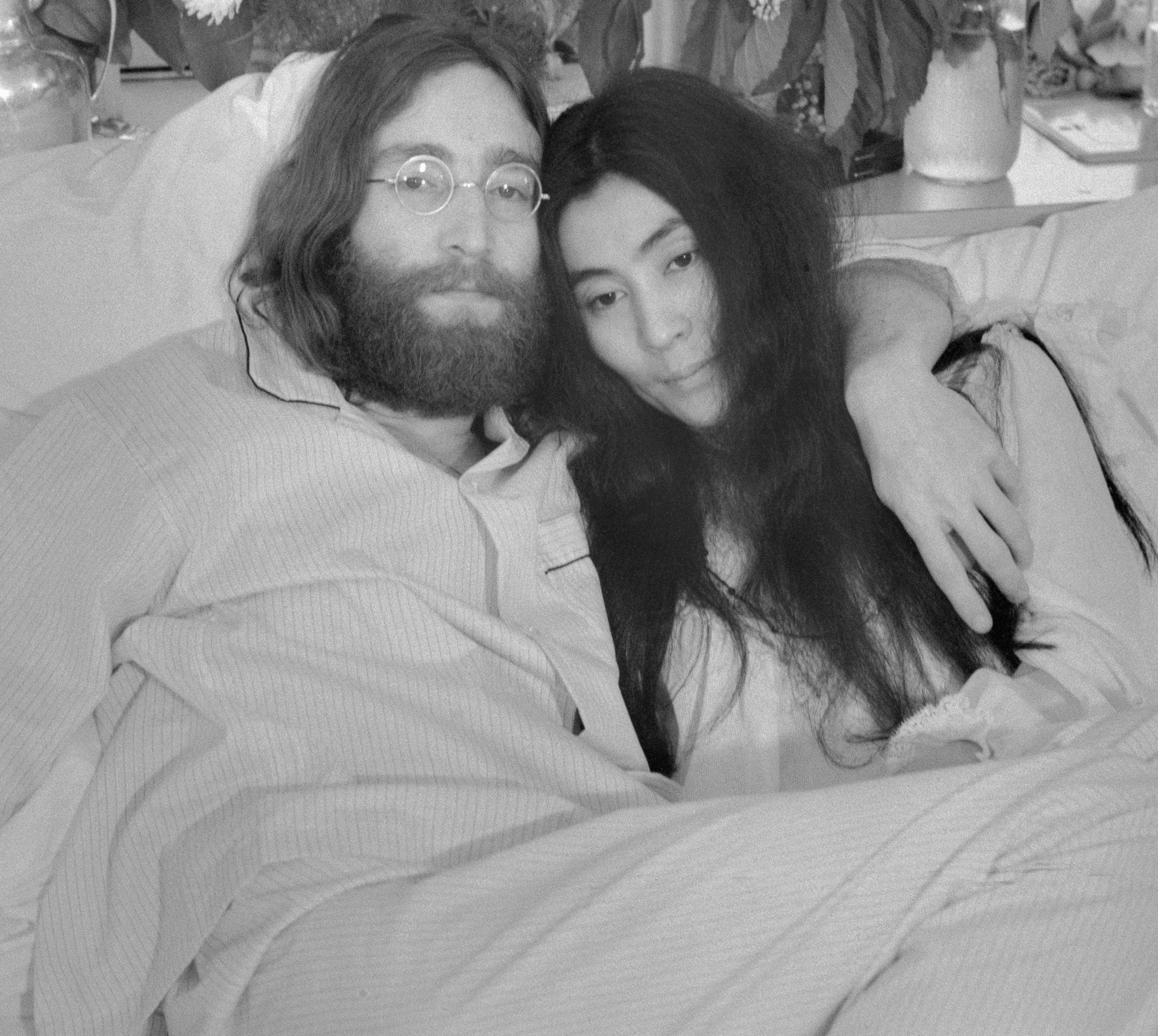 John Lennon and Yoko Ono on a bed