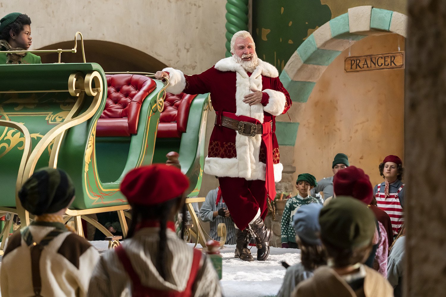 Tim Allen as Santa Clause surrounded by elves and his sleigh in The Santa Clauses.