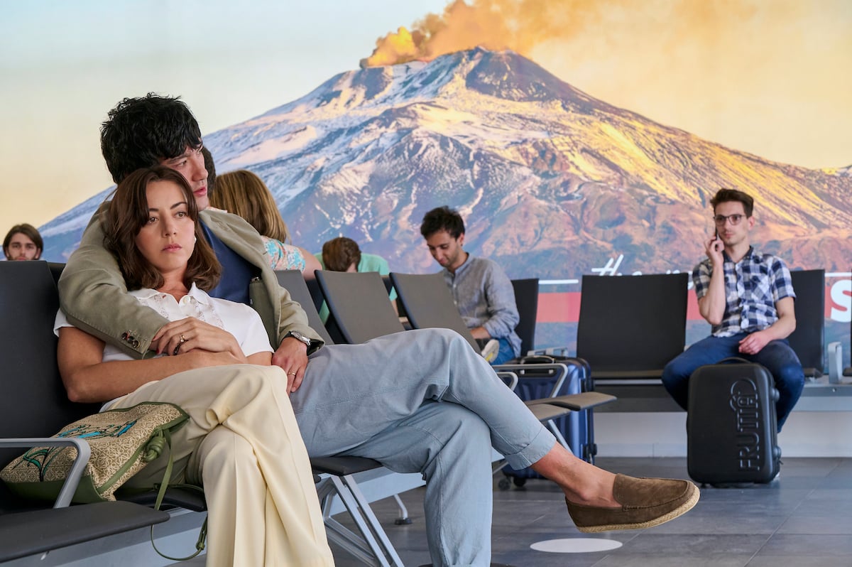 Harper (Aubrey Plaza) and Ethan (Will Sharpe) cuddle in the airport awaiting their flight home in 'The White Lotus Sicily' finale