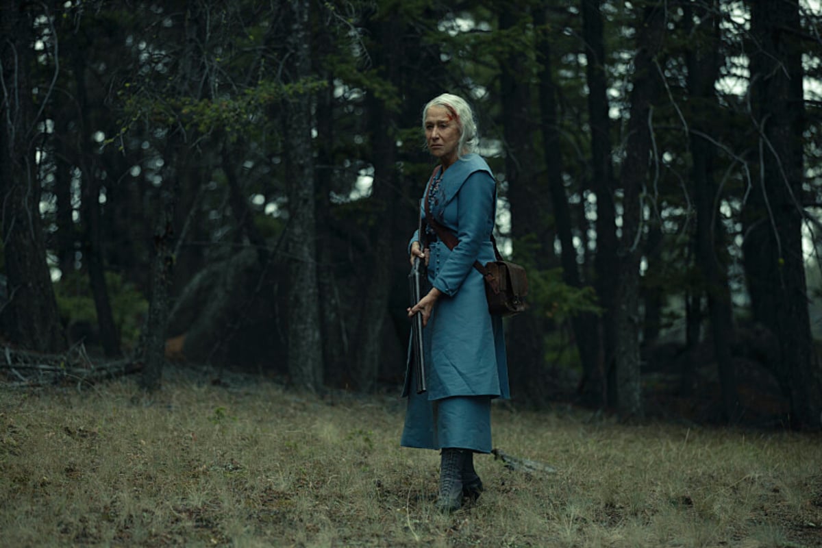 In the opening scene of 1923, Cara Dutton holds a shotgun and stands in the woods with blood on her forehead.