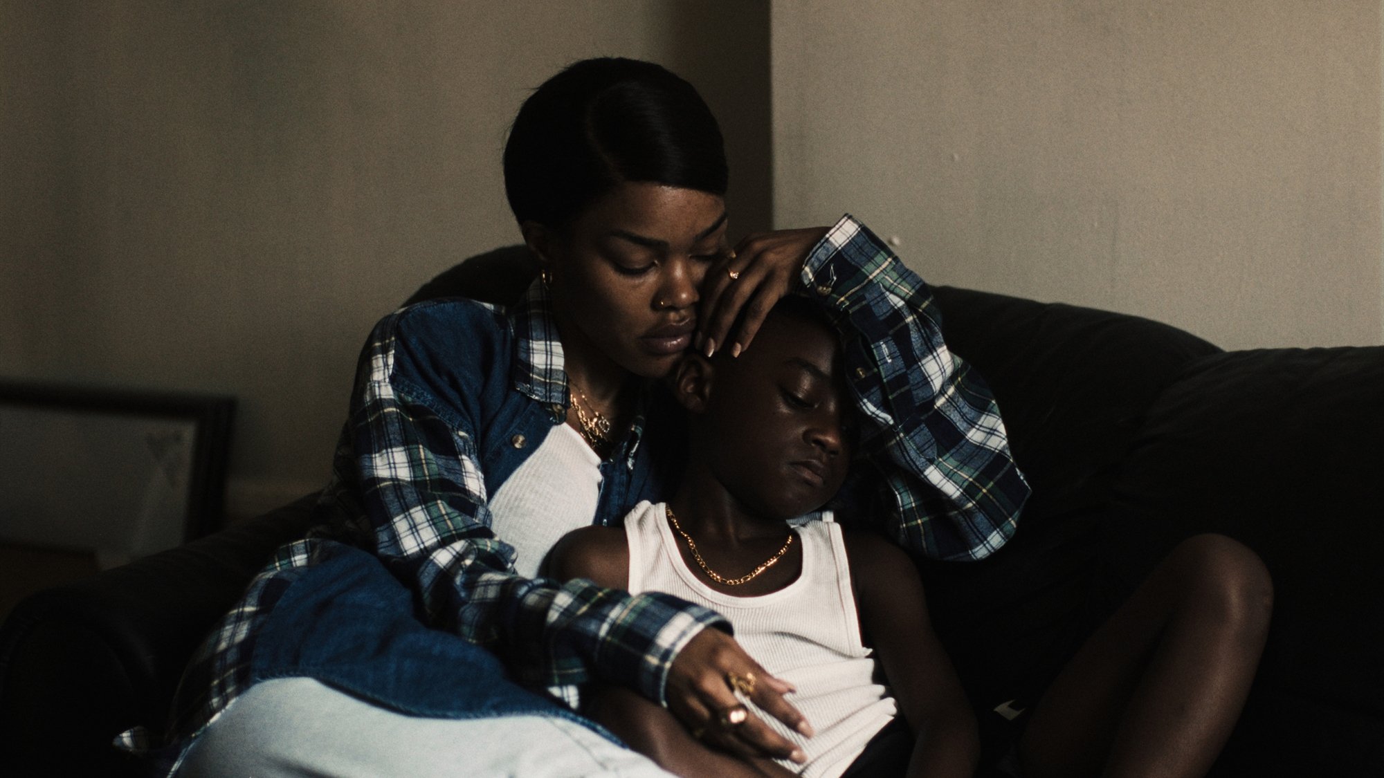 'A Thousand and One' Teyana Taylor as Inez and Aaron Kingsley Adetola as Terry. Inez is holding Terry from behind, both of them looking down.