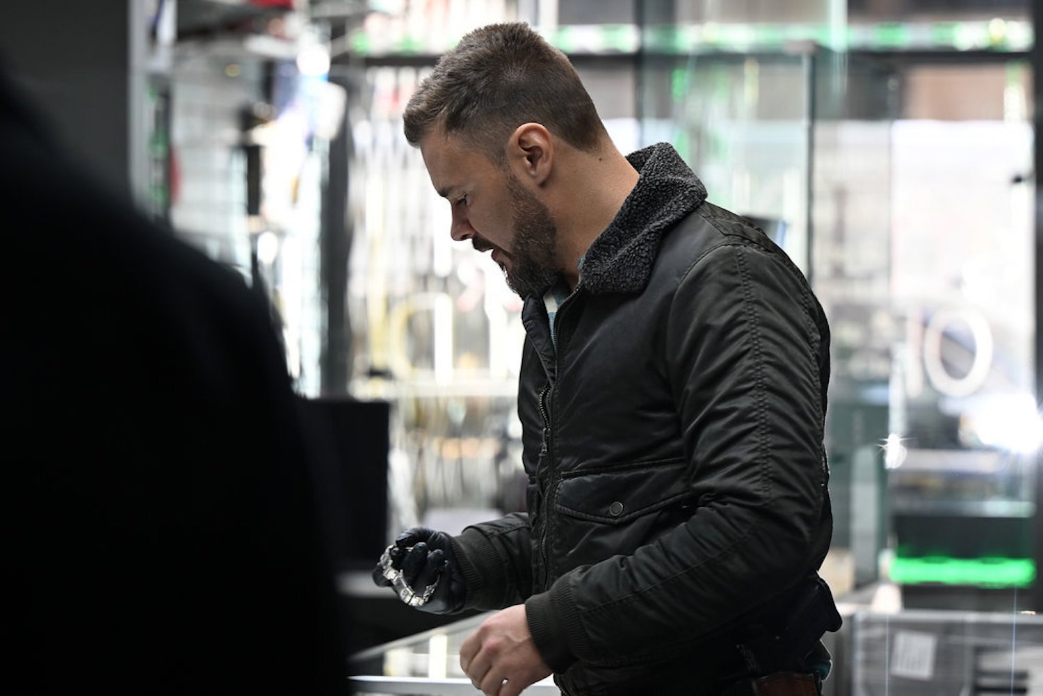 Adam Ruzek holding jewelry in a store in 'Chicago P.D.' Season 10