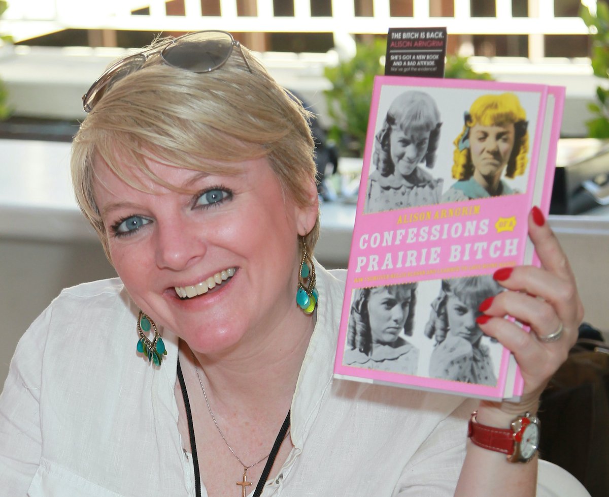 Alison Arngrim of 'Little House on the Prairie' holding up a copy of her book 'Confessions of a Prairie Bitch'