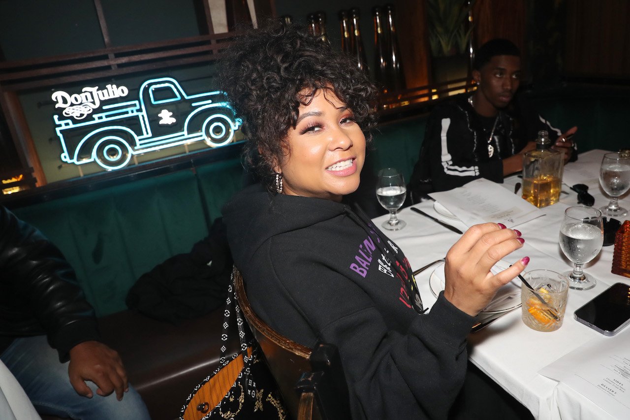 Angela Yee smiles at event while drinking