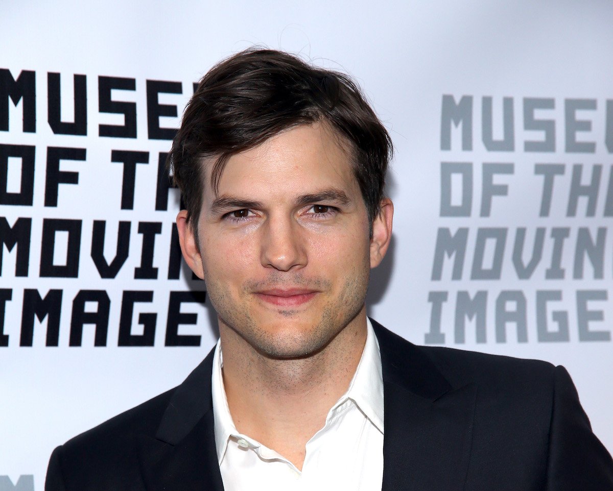 Ashton Kutcher, who will make an appearance on "That 90s Show," smiles and poses at an event.