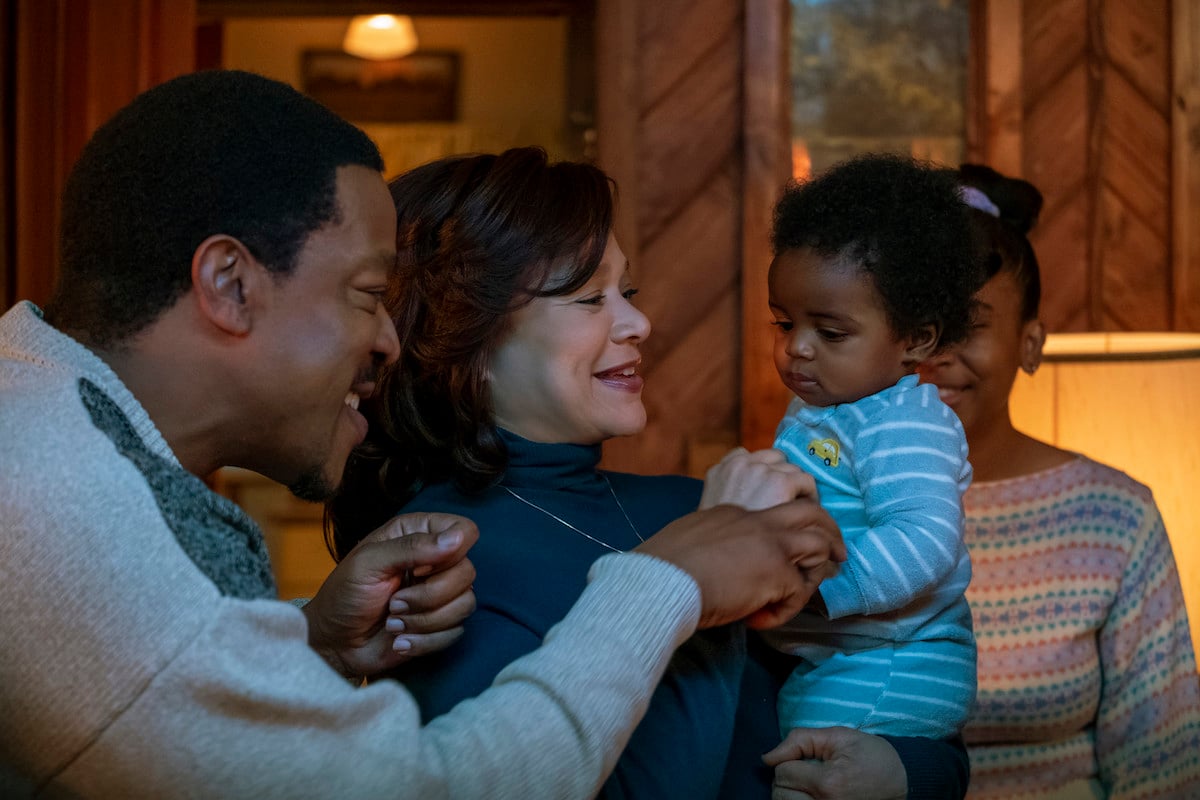 Russell Hornsby as Charles Flenory and Michole Briana White as Lucille Flenory smiling and playing with a baby in 'BMF'