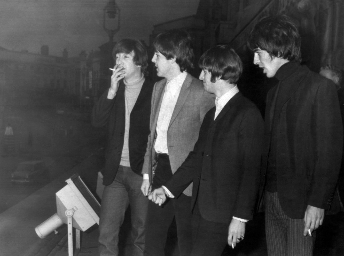 The Beatles' George Harrison smokes a cigarette backstage