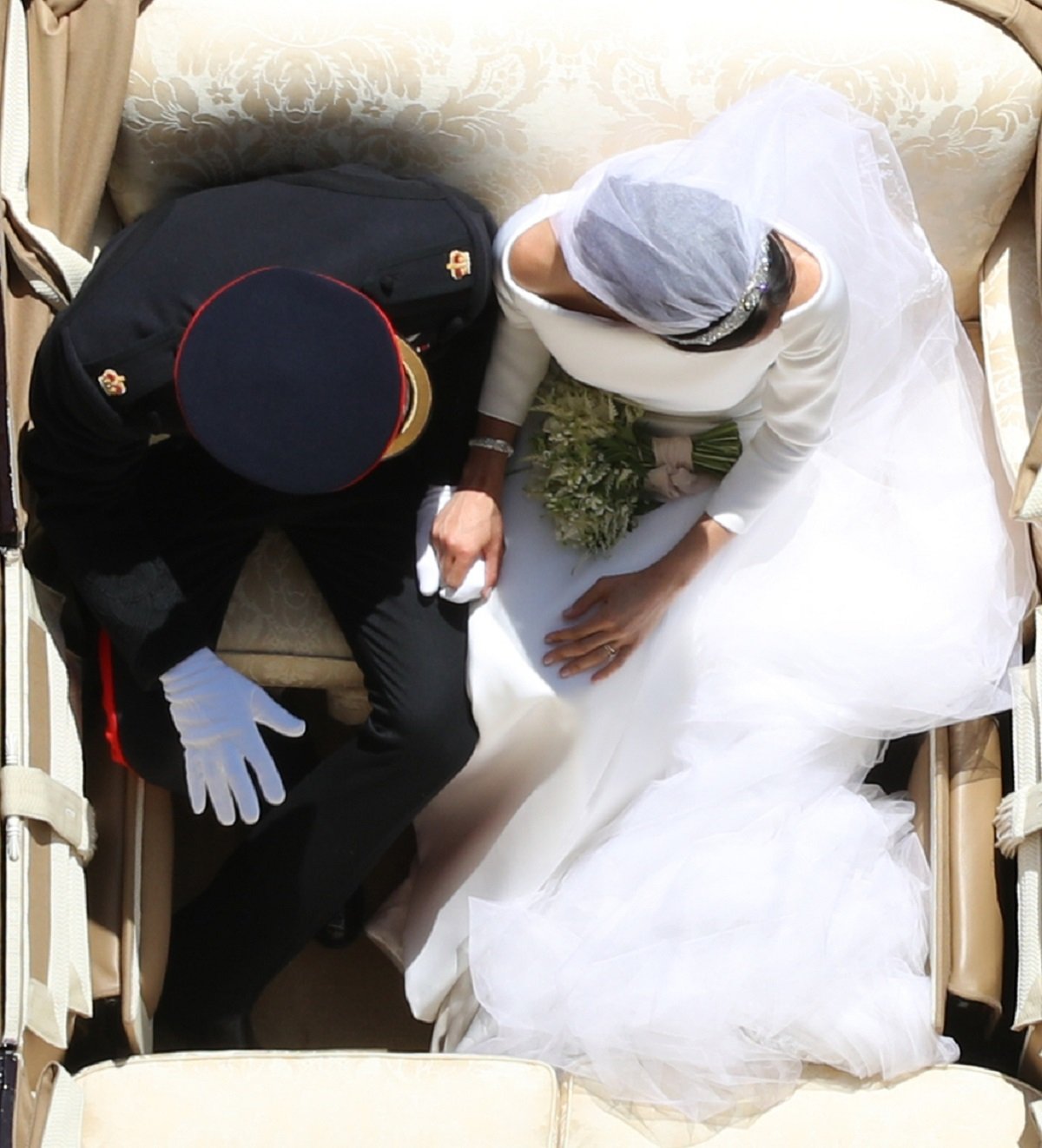 Bird's eye view of Meghan Markle and Prince Harry, who a body language expert analyzed demeanor in a wedding photo, holding hands in the Ascot Landau Carriage 