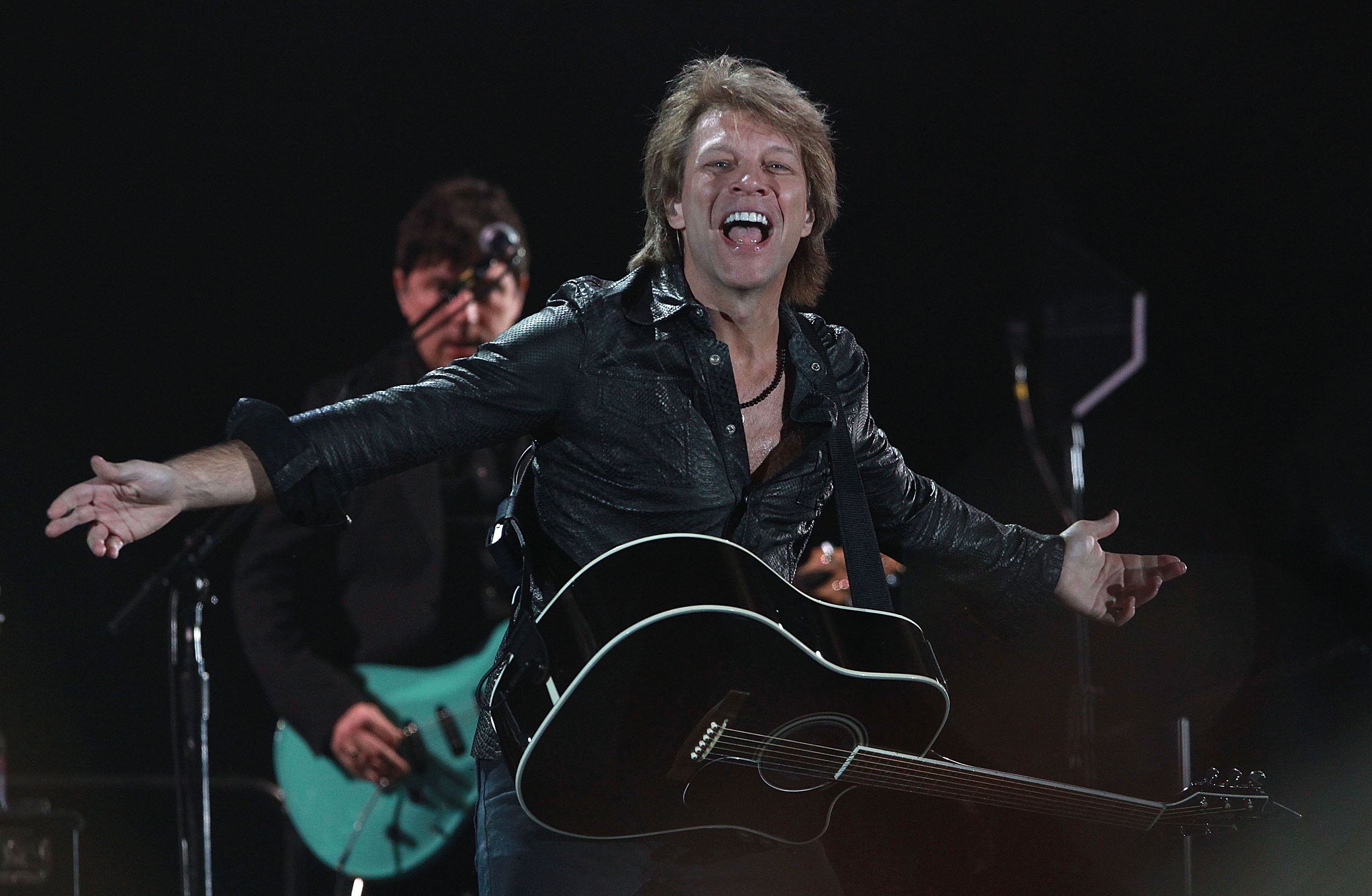 Bon Jovi stands on stage in all black, with a black guitar, during a performance at Etihad Stadium in Melbourne, Australia in 10`0