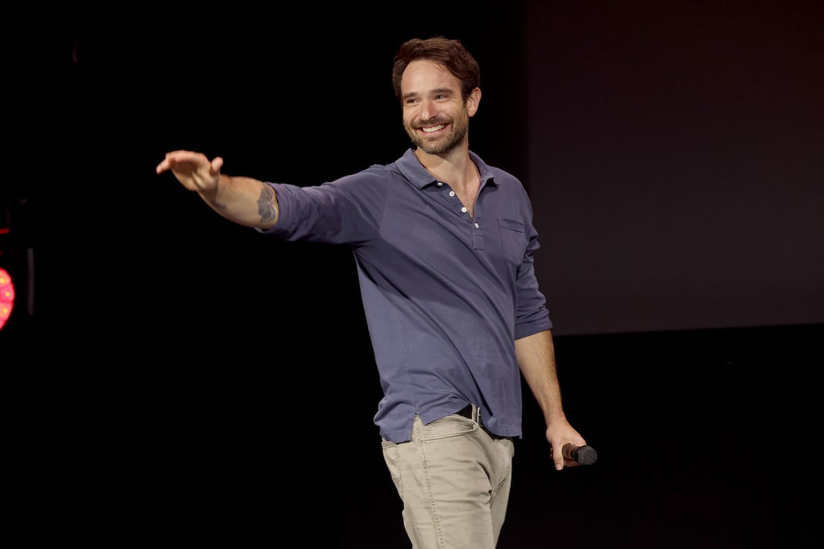 Actor Charlie Cox waves to fans at the D23 Expo 2022 wearing a henley shirt