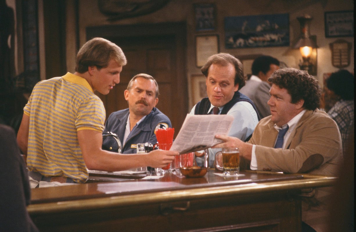 'Cheers': George Wendt and Woody Harrelson share a newspaper across the bar as Kelsey Grammer and John Ratzenberger look too