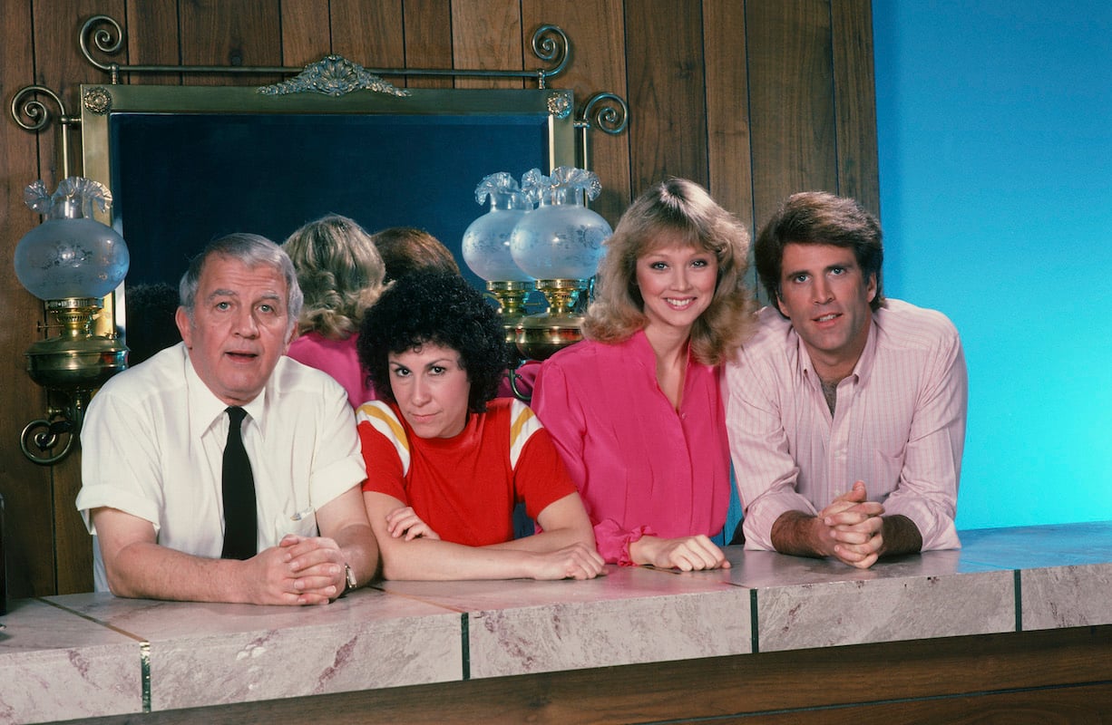 'Cheers' stars Nicholos Colasanto, Rhea Perlman, Shelley Long, and Ted Danson lean on a fake bar