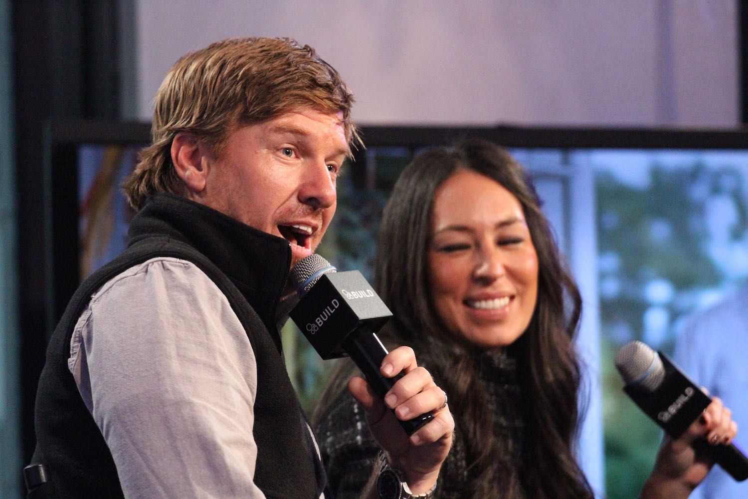 'Fixer Upper' stars Chip Gaines and Joanna Gaines speaking into microphones