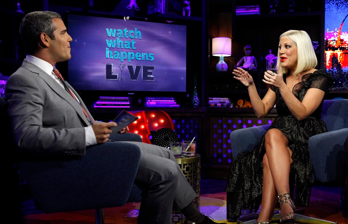 Tori Spelling sits across from Andy Cohen during an appearance on 'Watch What Happens Live with Andy Cohen. Cohen doesn't see Tori Spelling as a member of 'The Real Housewives of Beverly Hills'  