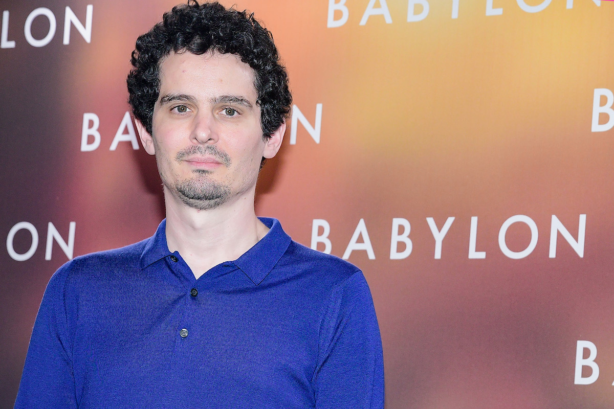 Director Damien Chazelle poses in front of the "Babylon" film logo