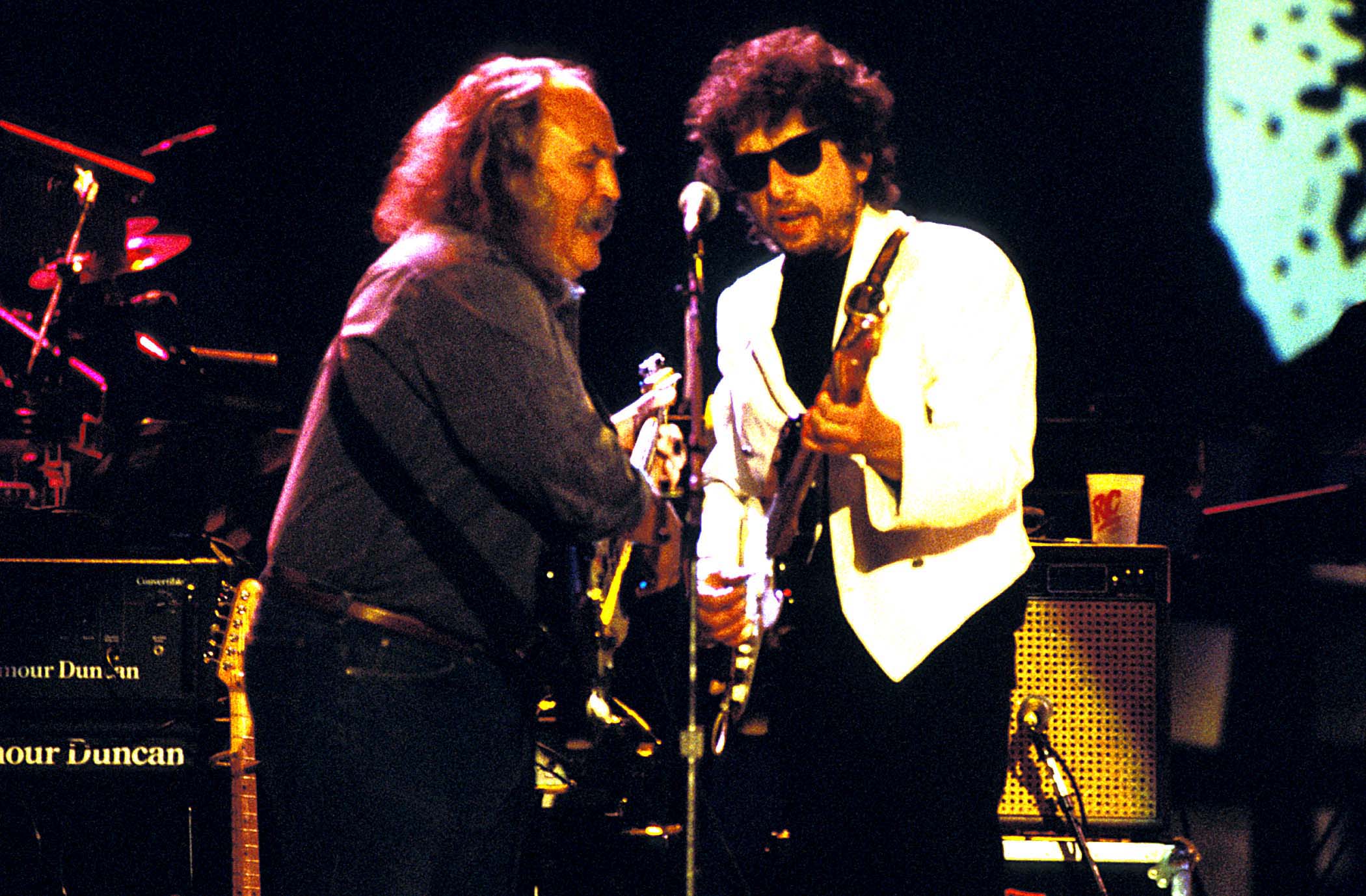 David Crosby and Bob Dylan play guitars and sing into the same microphone.
