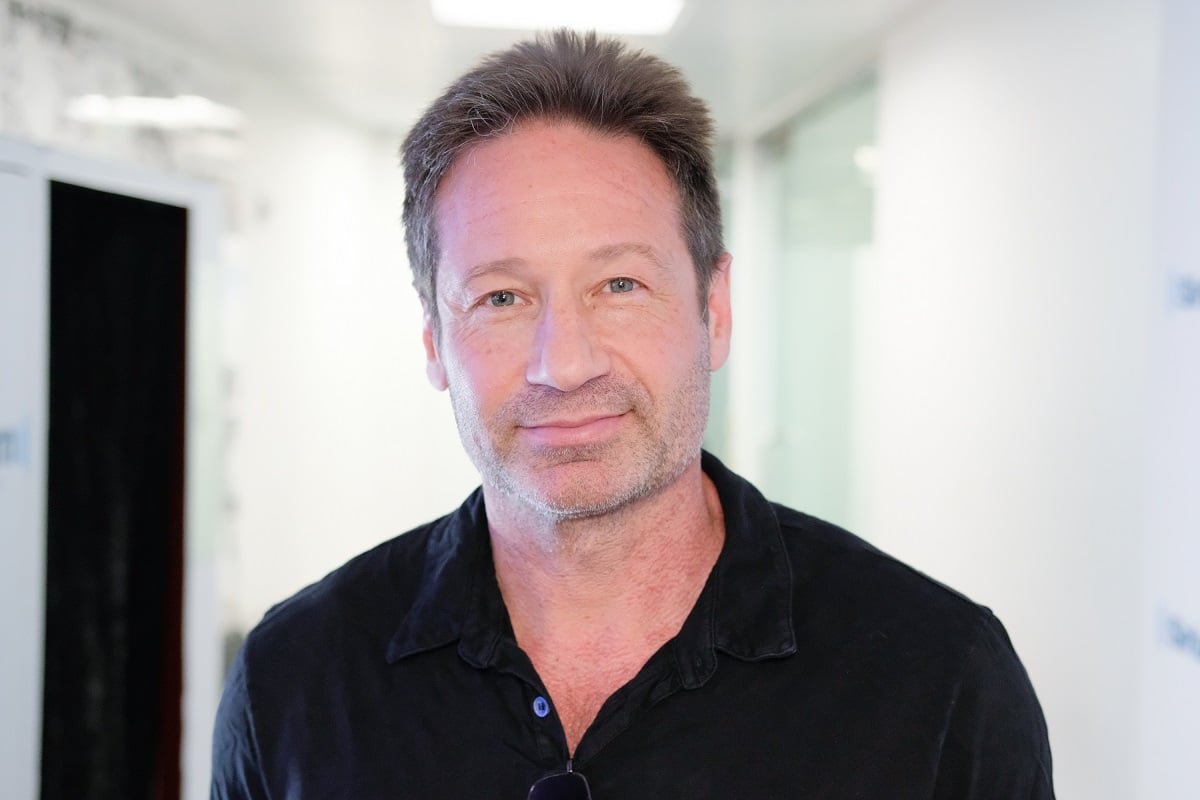 David Duchovny, wearing a black shirt, stands in the SiriusXM Studios in New York City