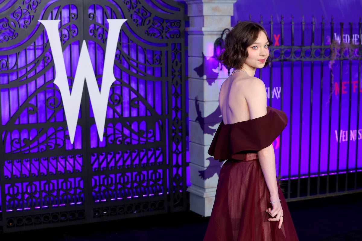 Actor Emma Myers poses in front oif a fence with a stylized "W" at the "Wednesday premiere.