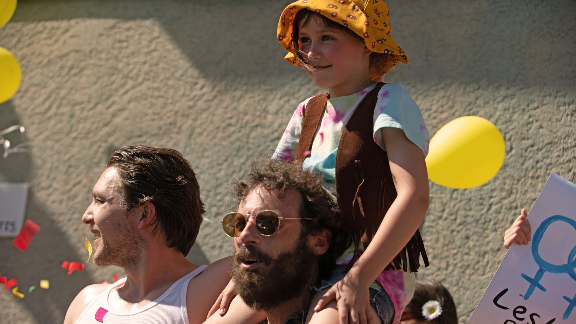 'Fairyland' Cody Fern as Eddie Body, Scoot McNairy as Steve Abbott, and Nessa Dougherty as Younger Alysia Abbott. Alysia is sitting on Steve's shoulders with Eddie standing next to them looking to the side.