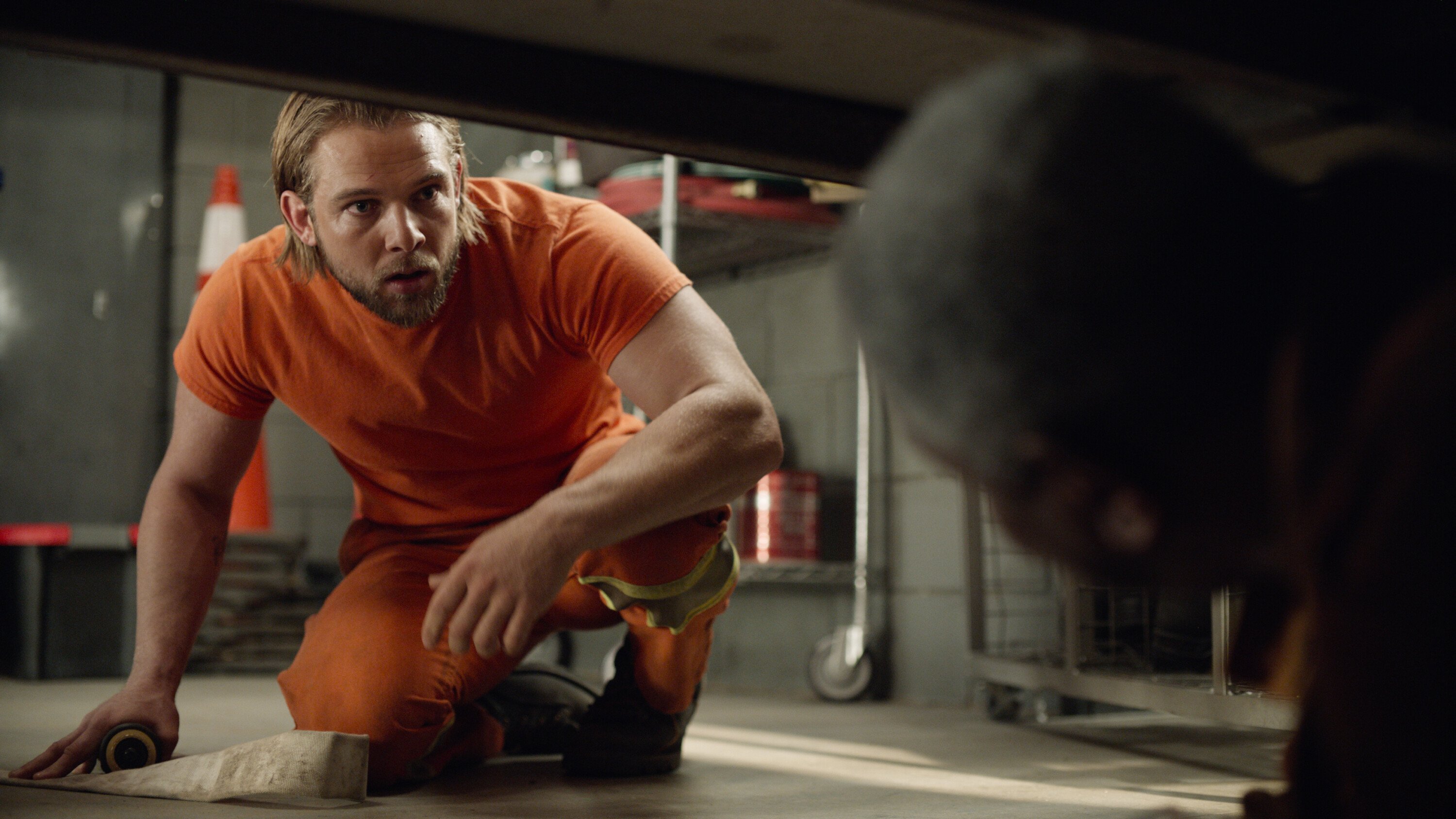 Max Thieriot as Bode looking under a table in the CBS series 'Fire Country'