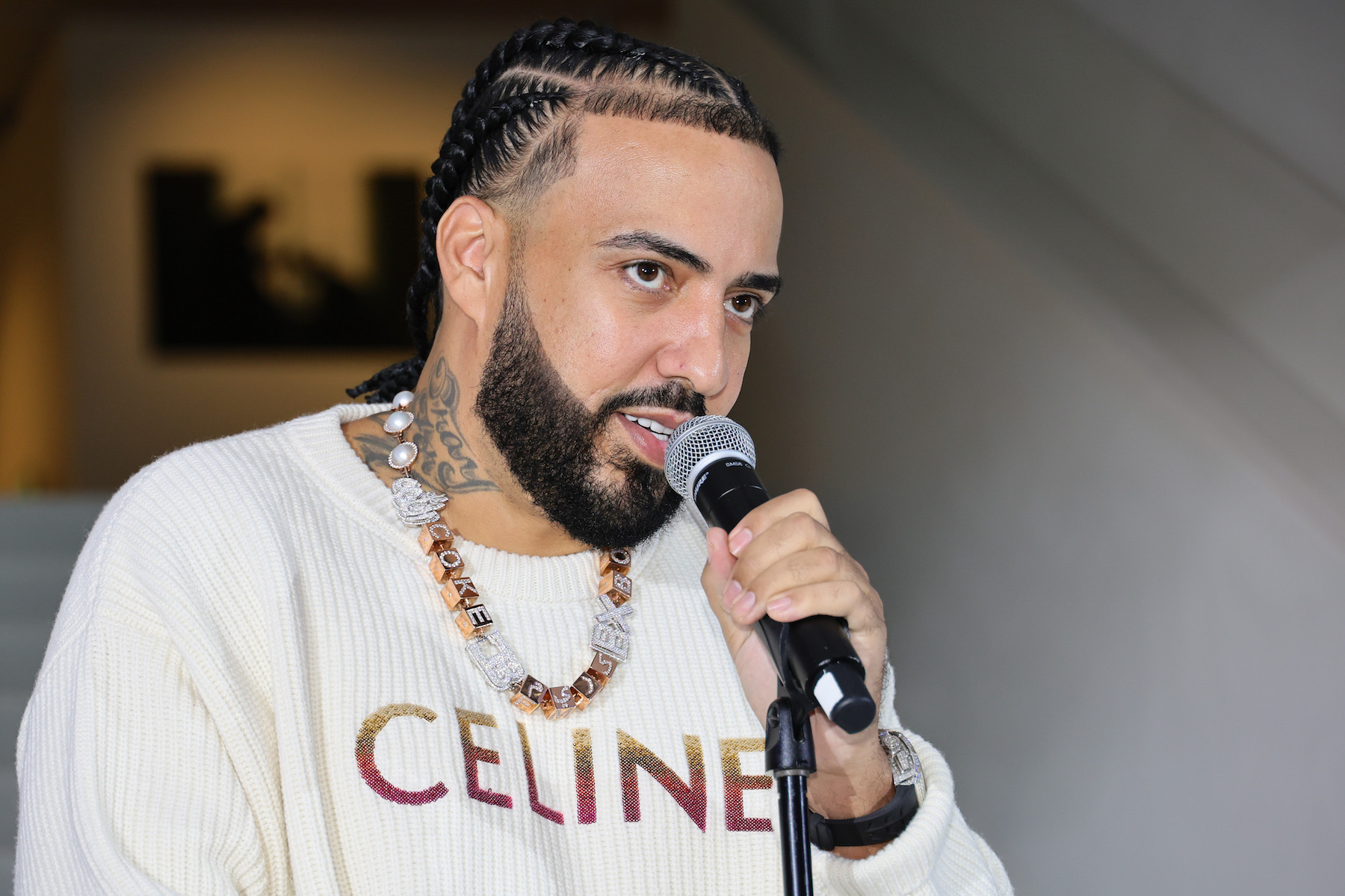French Montana, whose music video shoot in Miami was the location of a shooting, wearing a white shirt and speaking into a microphone
