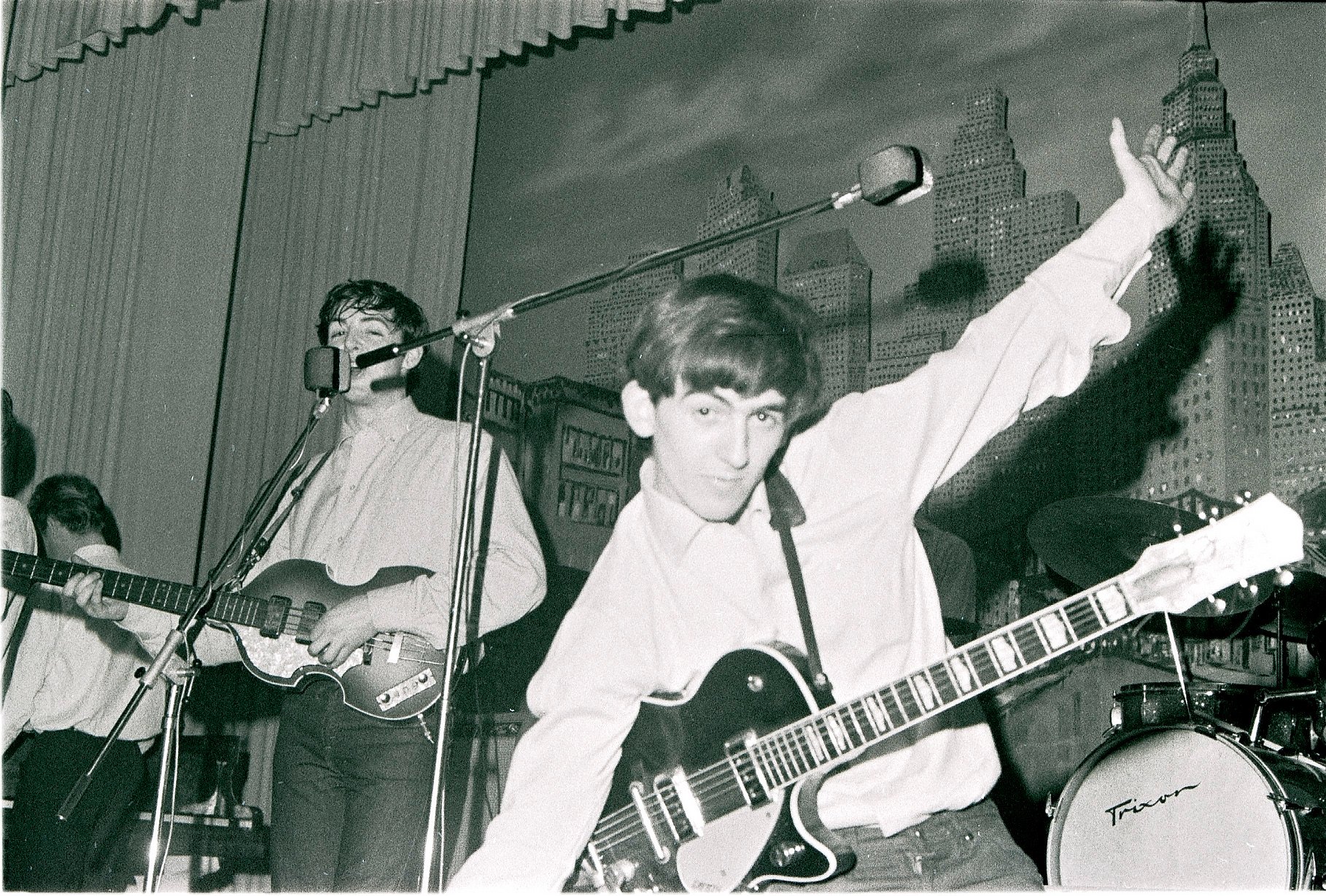A black and white picture of Paul McCartney and George Harrison onstage in Germany.