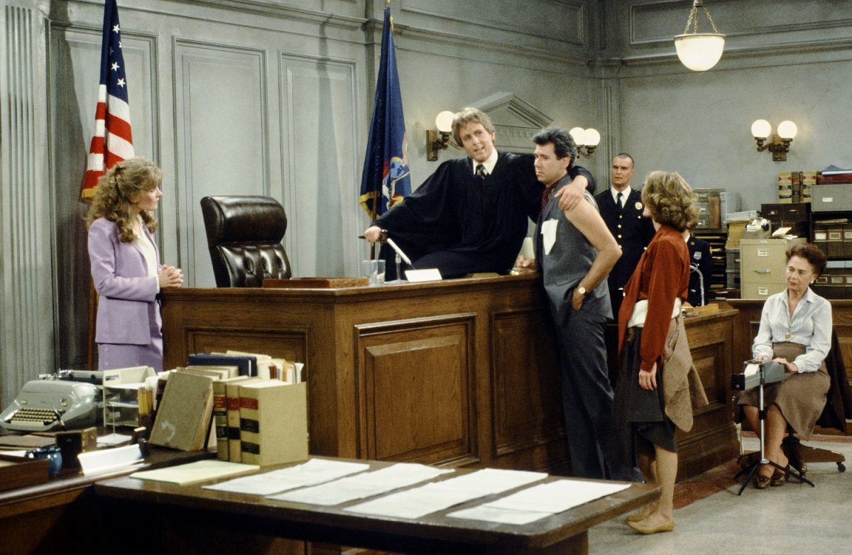 Karen Austin as Lana Wagner, Harry Anderson as Judge Harold "Harry" T. Stone, John Larroquette as Daniel R. "Dan" Fielding, and Gail Strickland as Public Defender Sheila Gardiner stand around the courthouse in season 1 of 'Night Court'