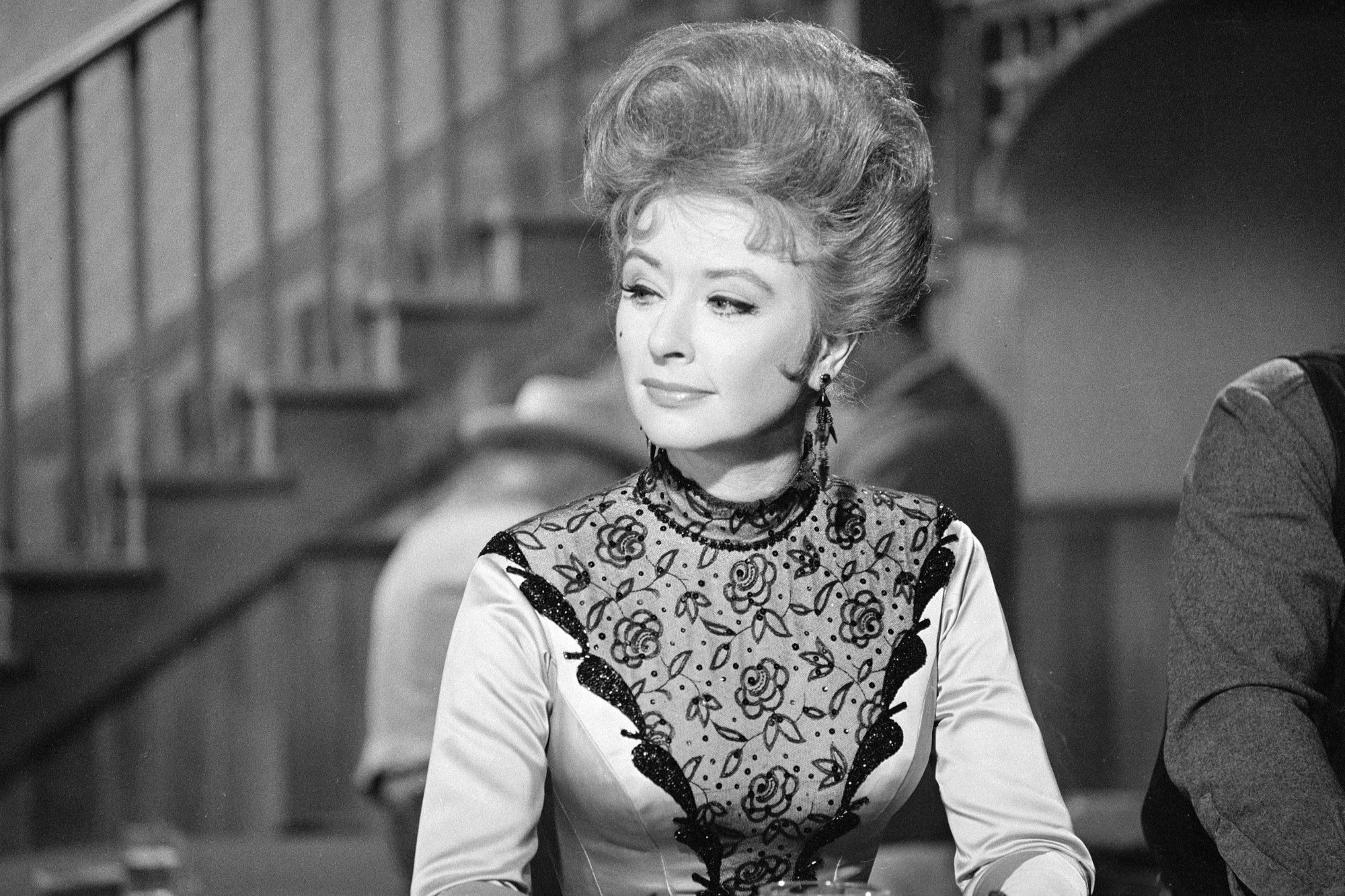 'Gunsmoke' Amanda Blake as Miss Kitty Russell in a black-and-white photo in front of a staircase
