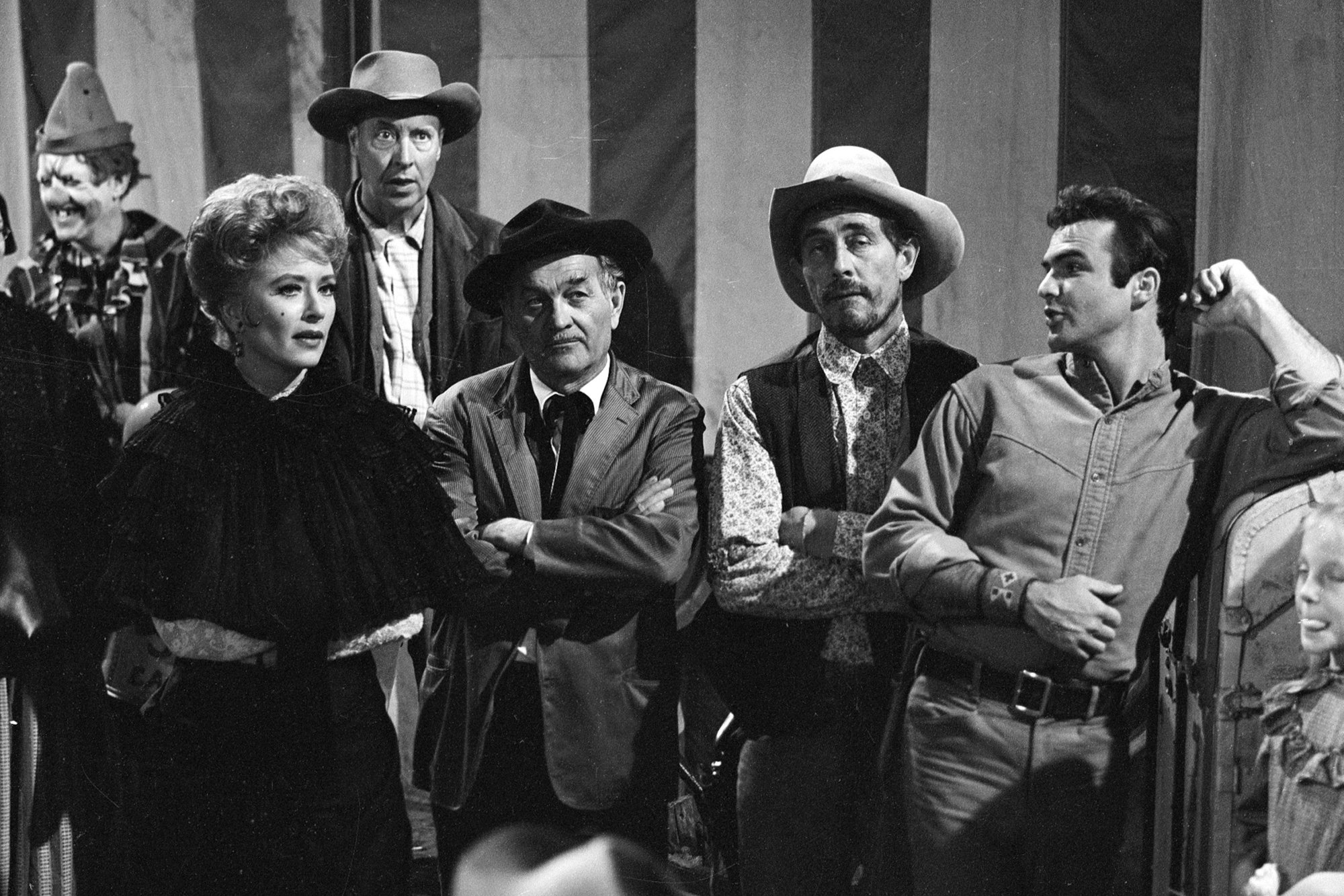 'Gunsmoke' episode 'Circus Trick' Amanda Blake as Kitty Russell, Milburn Stone as Doc Adams, Ken Curtis as Festus Haggen and Burt Reynolds as Quint standing at a circus looking upset with their arms crossed