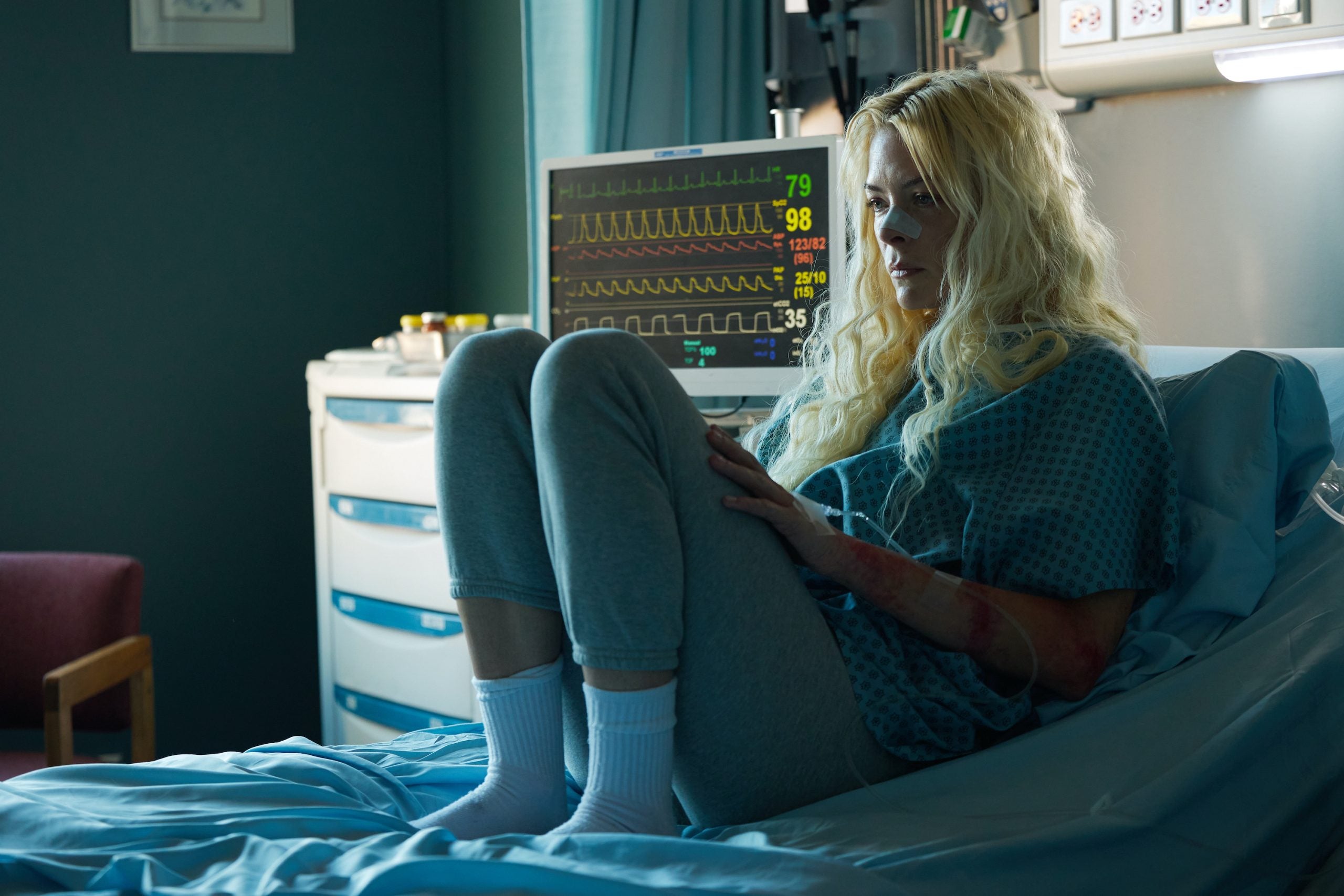 Jaime King, sitting on a hospital bed, as Sherri Papini in the Lifetime movie 'Hoax: The Kidnapping of Sherri Papini'