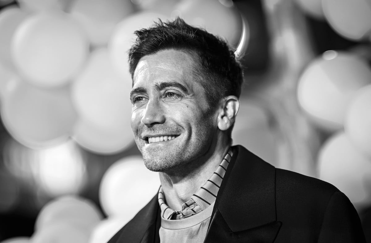 Black and white image of Jake Gyllenhaal posing for photos at the premiere of "Strange World"