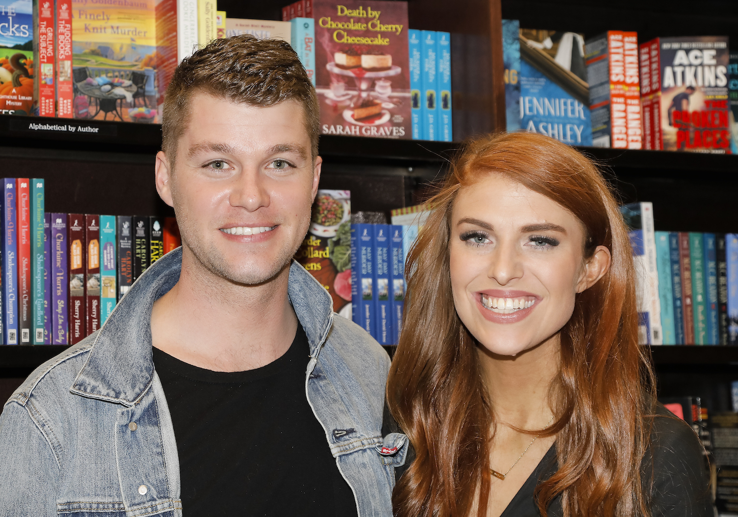 Jeremy and Audrey Roloff from 'Little People, Big World' smiling together with a bookshelf behind them