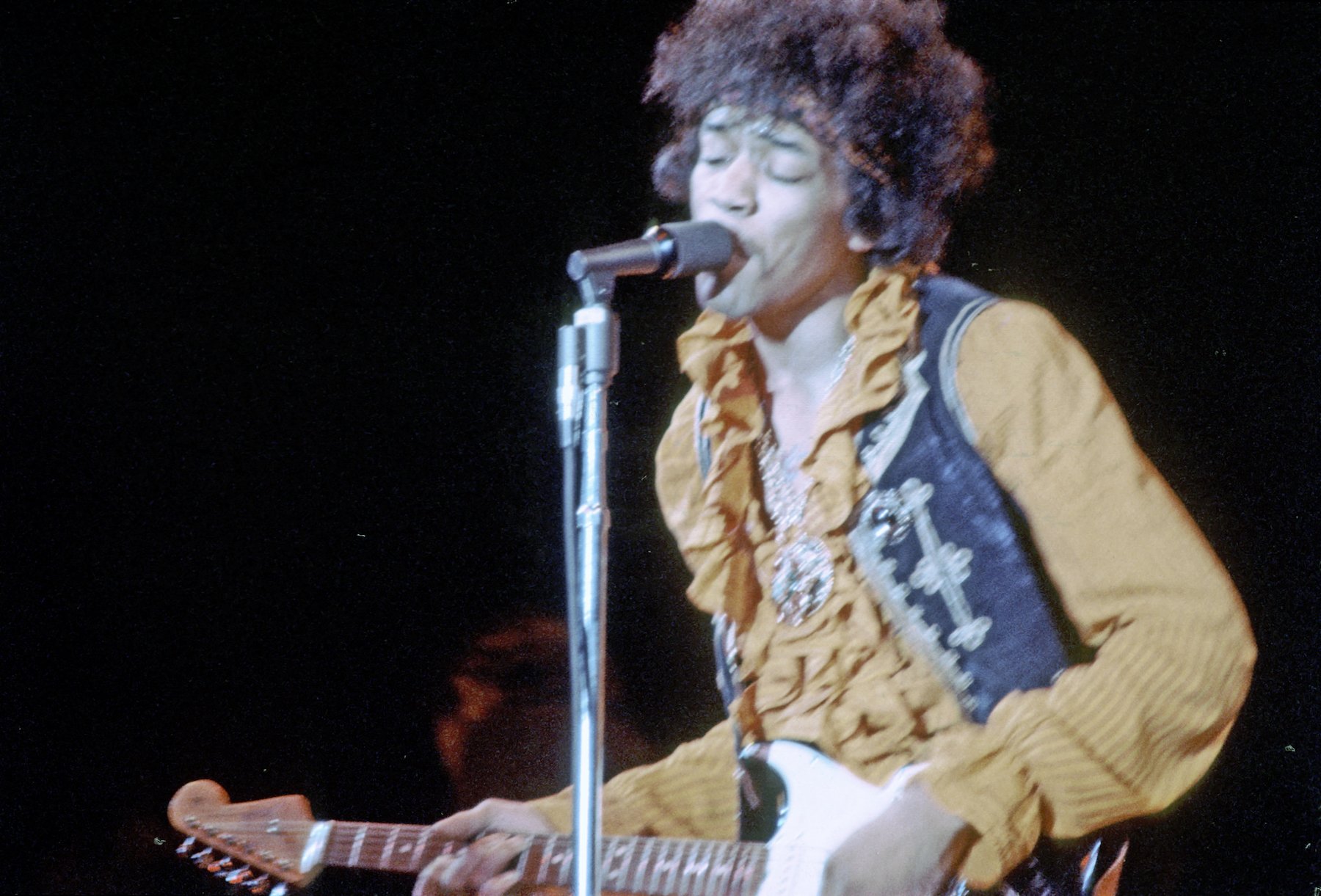 Jimi Hendrix, who played in several bands throughout his career, playing guitar