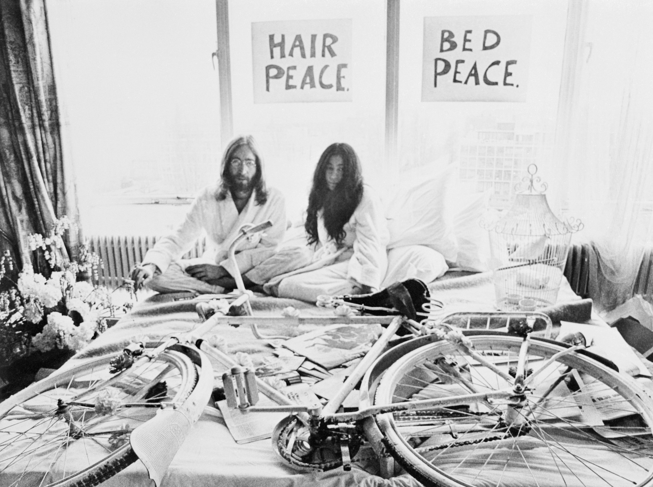 Beatle John Lennon and his bride of five days, Yoko Ono, pose in the Presidential Suite of the Amsterdam Hilton Hotel,