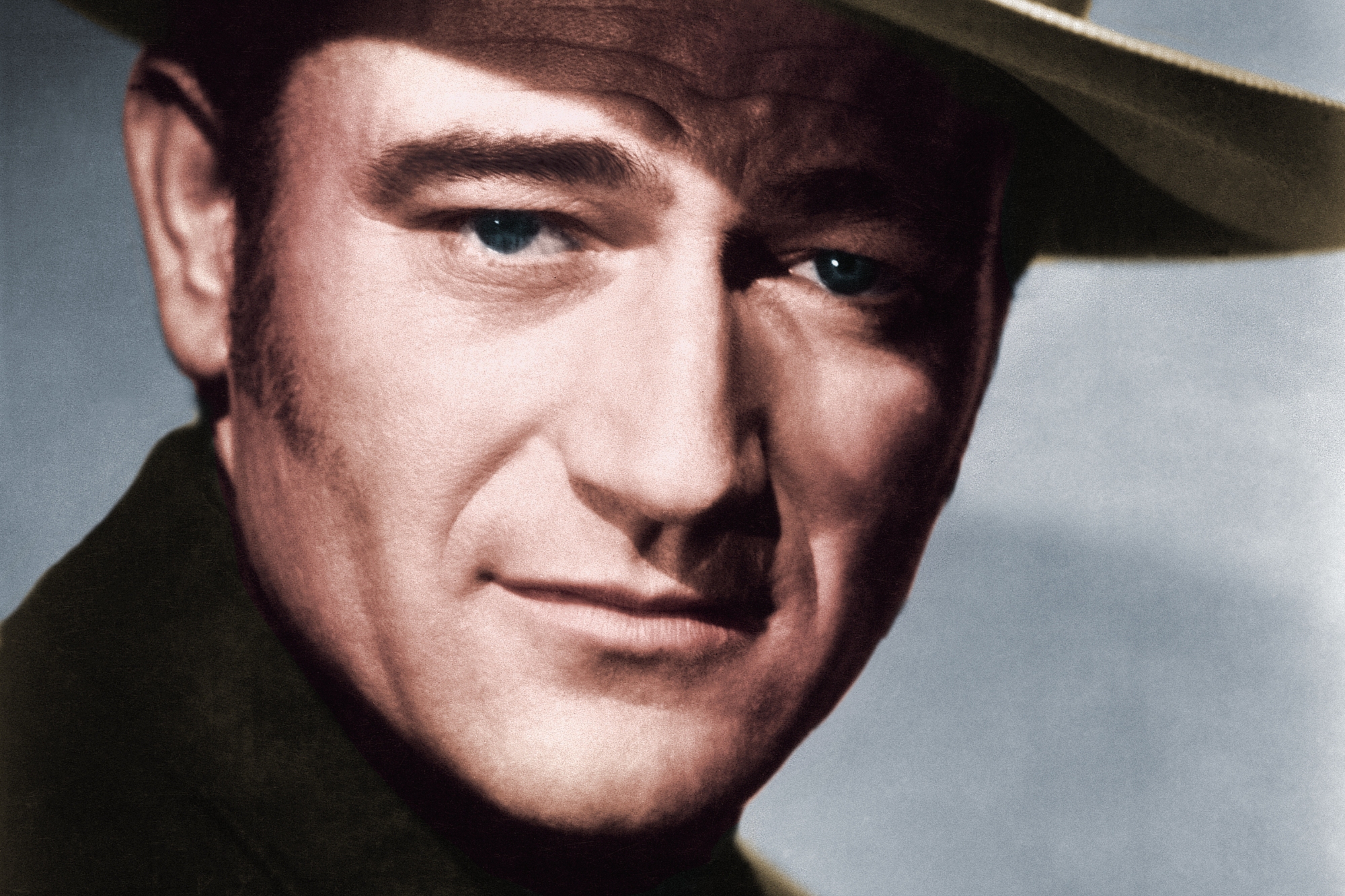 John Wayne, who lived by each phrase. He's wearing a cowboy hat looking at the camera