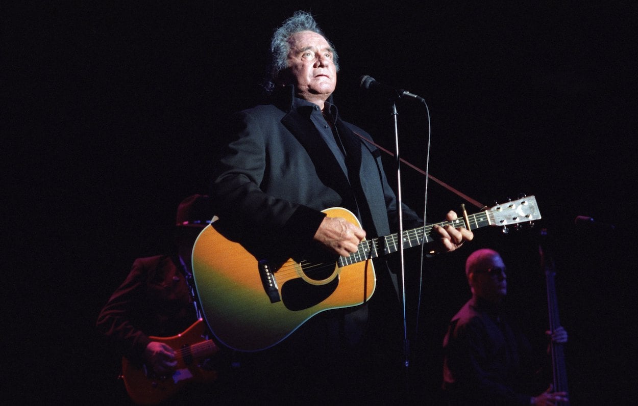 Johnny Cash strums his acoustic guitar as he performs at the Greek Theatre in Los Angeles in 1997.