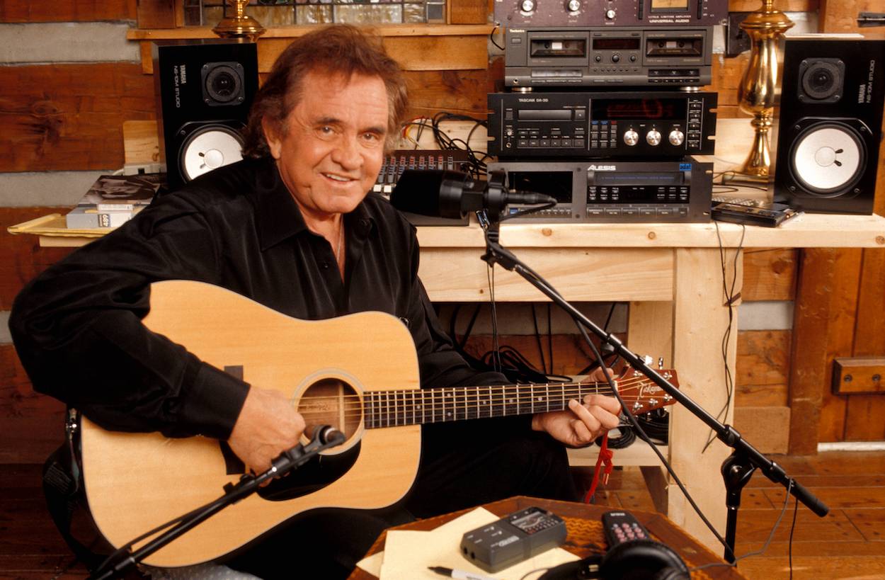 Johnny Cash recording in his home studio with his acoustic guitar circa 1994.