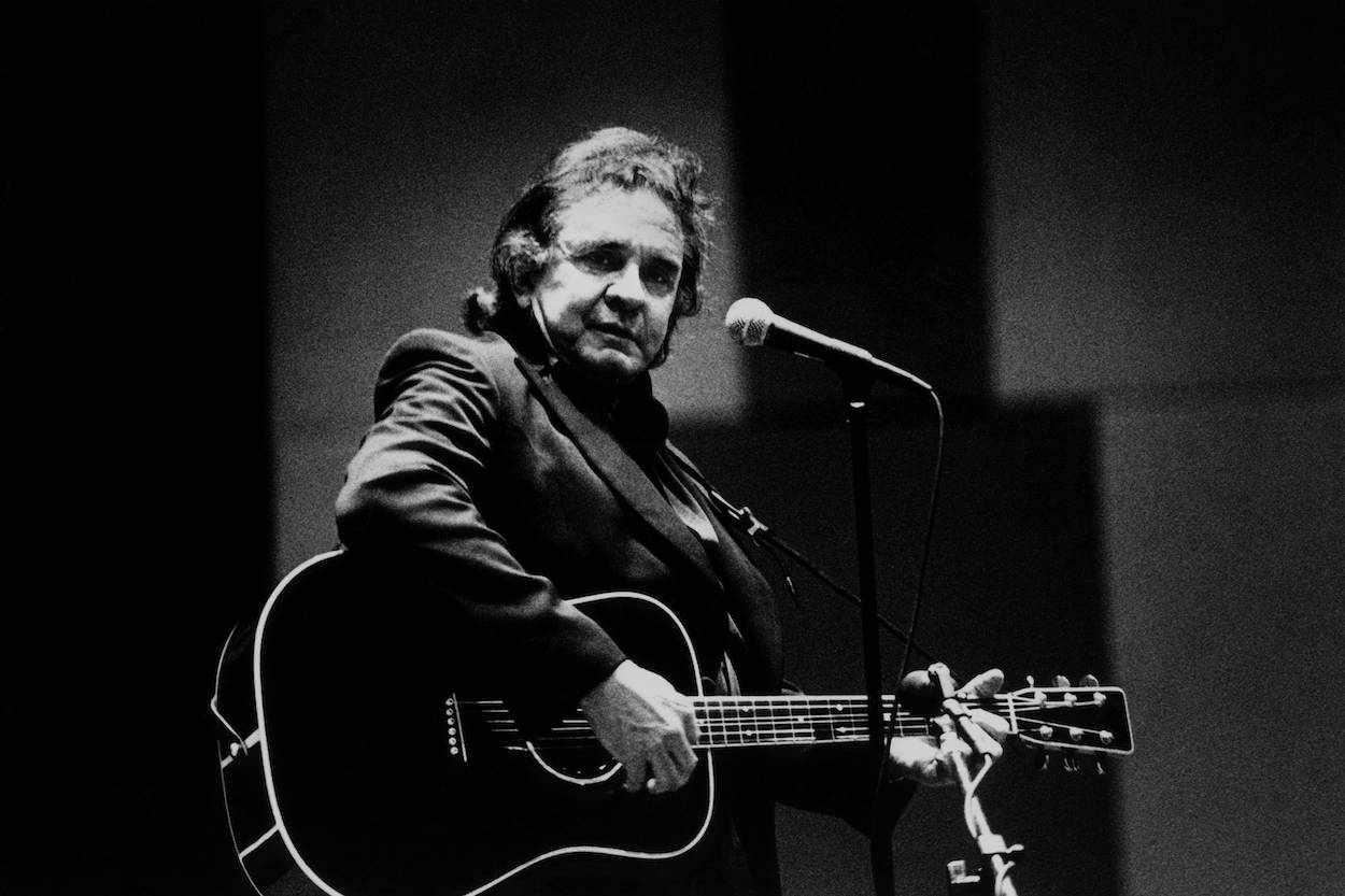 Johnny Cash performing with a black acoustic guitar in the Netherlands circa 1994.