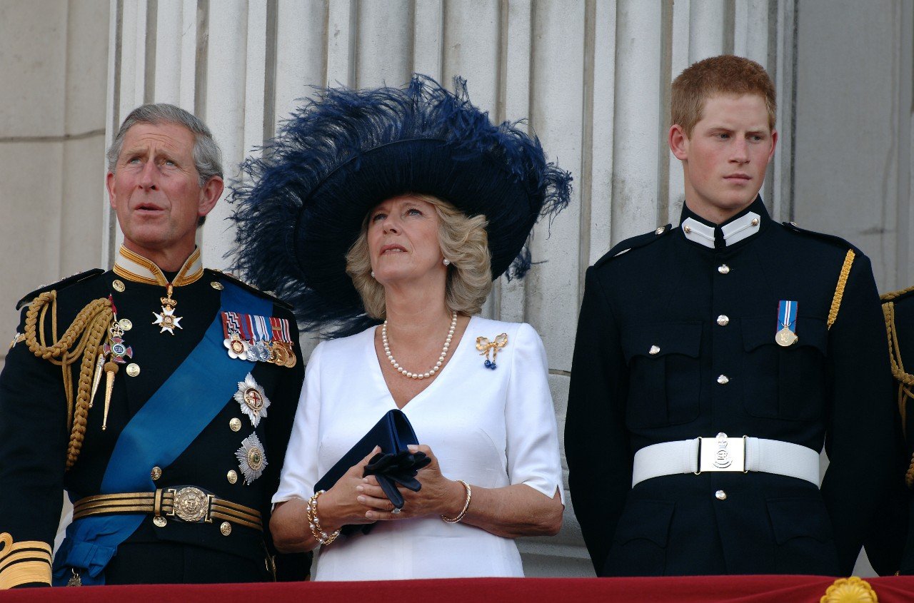 King Charles, Queen Camilla, and Prince Harry stand on the balcony.